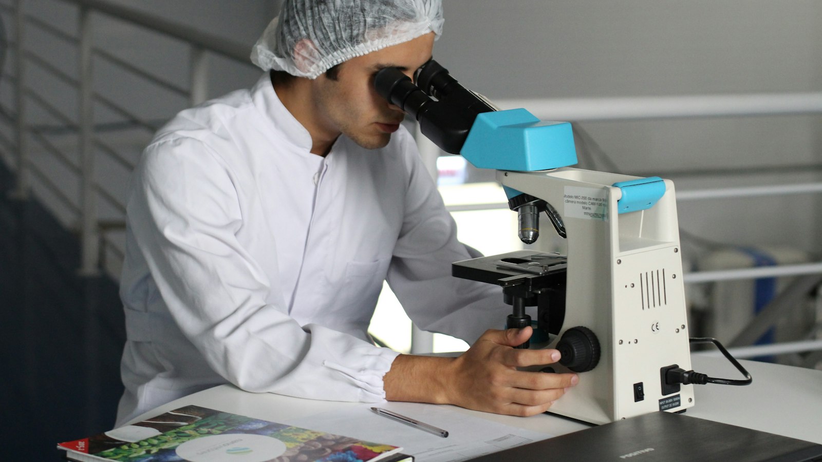 A researcher looks through a microscope